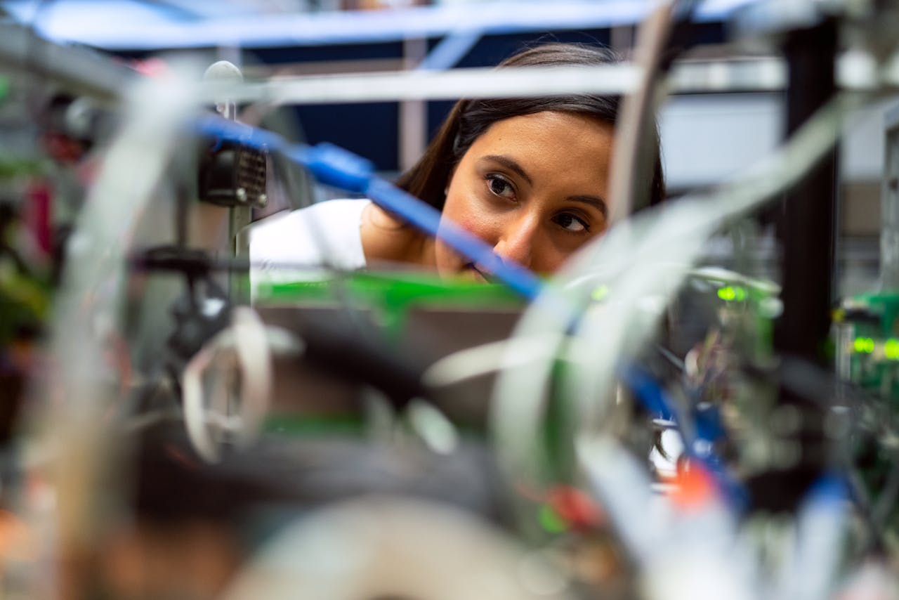 A person inspects the wiring of a machine. Image by This Is Engineering on Pexels.